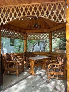 a wooden gazebo with a wooden table and chairs at Дом СКАЗКА in Astana +31 photos