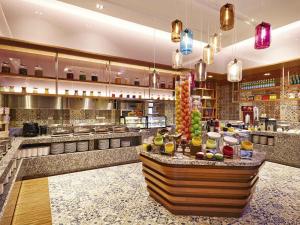 a restaurant with a counter with food in it at Mercure Kuala Lumpur Shaw Parade in Kuala Lumpur