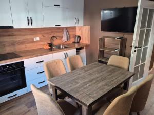 a kitchen with a wooden table with chairs and a sink at Meli Deluxe in Prizren