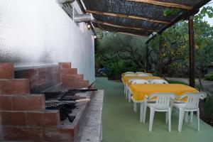 a row of tables with white chairs and a grill at Spathies in Kalogria