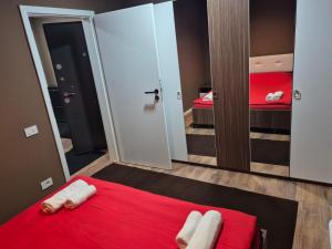 a bedroom with a red bed and a mirror at Meli Deluxe in Prizren