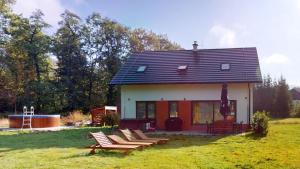 a small house with lounge chairs in a yard at Dům v srdci Beskyd - Morávka - 6 pokojů in Morávka +24 photos