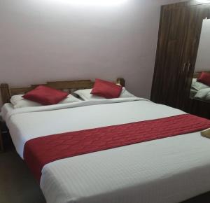 a bedroom with two beds with red pillows at Vasantharaja Villa Ariyankuppam in Pūrnānkuppam +4 photos