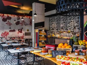 ein Restaurant mit Tischen und Stühlen sowie Obst und Gemüse in der Unterkunft ibis Styles Barcelona City Bogatell in Barcelona