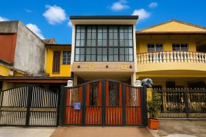 a house with a red gate in front of it at Batu Caves Cozy 2 Storey House with Free Netflix in Batu Caves