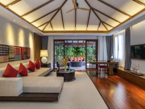a living room with a couch and a table at Pullman Luang Prabang in Luang Prabang