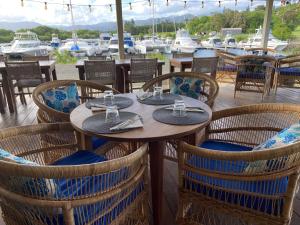 a table and chairs at a restaurant with a marina at Gîte Les Escales La Marina in Bouloupari