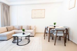 a living room with a couch and a table and chairs at Modern 1BR with Beach and Pool in Al Marjan Island in Ras al Khaimah