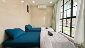 a large blue couch in a room with a window at Batu Caves Cozy 2 Storey House with Free Netflix in Batu Caves