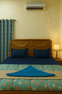 1 dormitorio con 1 cama con sábanas azules y ventilador en Vinayaka Heritage, en Patna 23 fotos más
