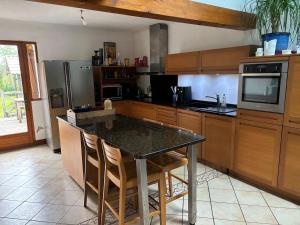 a kitchen with a table with chairs and a refrigerator at Maison familiale à louer in Bénesse-Maremne +5 photos