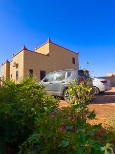 two cars parked in a parking lot in front of a building at Dar Amrad in Hassilabied