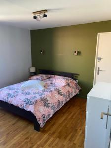 a bedroom with a bed with a floral comforter at Le Rive & Chêne Apartment in Aurillac