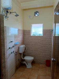 a bathroom with a toilet and a shower and a window at VIP Residency Hotel And Restaurant in Shānti Niketan +16 photos