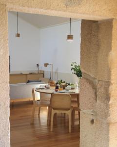 a room with a table and chairs and a bed at Quintal do Forno l Casa da Hera in Paços da Serra
