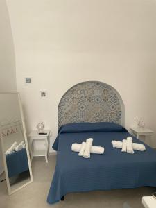 ein Schlafzimmer mit einem blauen Bett mit Handtüchern darauf in der Unterkunft Case Nuove in Gallipoli