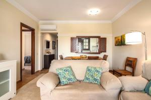 een woonkamer met een bank en een bed bij Los Albatros by Ĥ - Playa de los Haraganes HAHB30P190 in Isla Canela