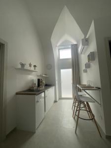 eine Küche mit einem Stuhl und einem Tisch und einem Fenster in der Unterkunft Case Nuove in Gallipoli + 8 Fotos