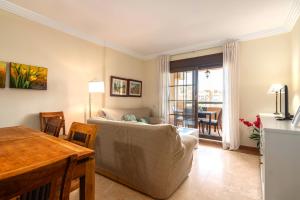 een woonkamer met een bank en een tafel bij Los Albatros by Ĥ - Playa de los Haraganes HAHB30P190 in Isla Canela