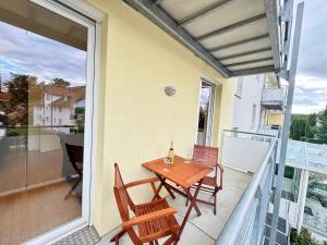 a table and chairs on a balcony with a bottle of wine at Renaissance Boutique Apartment - Bad Krozingen in Bad Krozingen