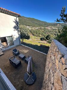 eine Terrasse mit einem Sonnenschirm, Stühlen und einem Tisch in der Unterkunft Appartement proche de la rivière et de la plage ! in Vico