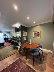 a living room with a wooden table and chairs at Somerset West Garden Apartments 4 in Somerset West +60 photos