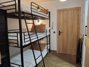 a room with three bunk beds and a door at Plaza Andalucía Edificio Dornajo in Monachil
