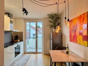 a kitchen with a table and a refrigerator at Renaissance Boutique Apartment - Bad Krozingen in Bad Krozingen