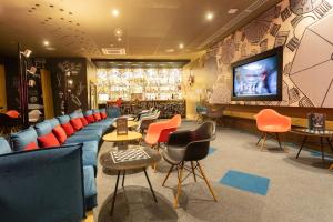 a bar with colorful chairs and a tv in a room at Ibis Rabat Agdal in Rabat
