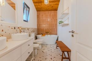 Un baño con dos lavabos, una bañera y un inodoro. en Westwand Villas, en Măgura 88 fotos más