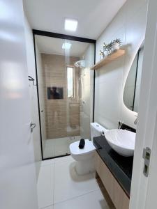 a white bathroom with a sink and a toilet at Feel Home Duplex no Bessa com Jacuzzi Privativa in João Pessoa +10 photos