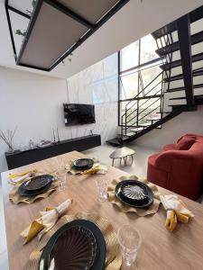 a dining room table with plates and glasses on it at Feel Home Duplex no Bessa com Jacuzzi Privativa in João Pessoa
