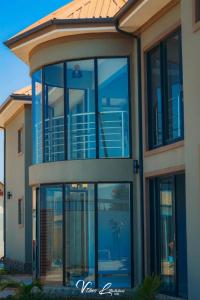 ein Haus mit großen Glasfenstern an der Seite in der Unterkunft B First Complex in Kolwezi