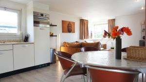 a kitchen and living room with a table and a couch at Park Welgelegen, bungalow 67 in Cadzand