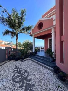 a building with a palm tree in front of it at VILLA Valhalla Private heated swimming-pool in Funchal