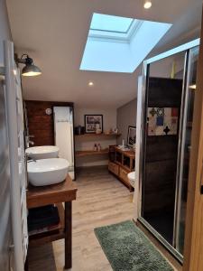La salle de bains est pourvue d'une douche, d'un lavabo et d'une lucarne. dans l'établissement La Grange, à Orcet