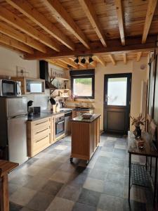 une grande cuisine avec des plafonds en bois et une table dans l'établissement La Grange, à Orcet