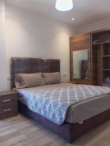 a bedroom with a large bed with a wooden headboard at Casa de Marinero in Martil