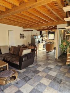 un salon avec un canapé et une cuisine dans l'établissement La Grange, à Orcet