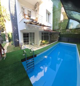 a swimming pool in the backyard of a house at ELIT1 Villa 10 BEDS FULL TRIPLEX VILLA in BELEK Golf area with PRIVATE POOL & GARDEN WIFI NETFLIX Full Kitchen & Bed Equipments Air Conditions free parking in Belek