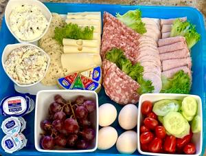 a tray of food with meat vegetables and other foods at Rezydencja Wind Rose - luxury ApartHotel Gdansk in Gdańsk +68 photos