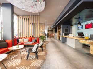 een lobby van een restaurant met rode stoelen en tafels bij ibis Geneve Centre Lac in Genève