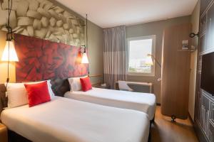 a hotel room with two beds and a tv at Ibis Rabat Agdal in Rabat +167 photos