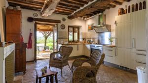 a kitchen with wicker chairs and a table at Ca Lucciola 12 by Marche Holiday Villas in Montemaggiore al Metauro