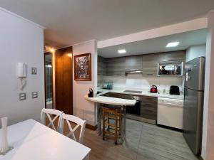 a kitchen with a table and a refrigerator at Arriendo dos dormitorios Costas in Concón