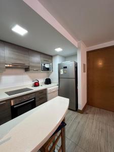 a kitchen with a stainless steel refrigerator and a table at Arriendo dos dormitorios Costas in Concón +11 photos