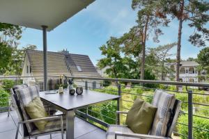 a patio with a table and chairs on a balcony at Ferienwohnung Meerzeit in der Villa Düne Binz in Binz