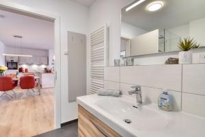 a white bathroom with a sink and a kitchen at Ferienwohnung Meerzeit in der Villa Düne Binz in Binz