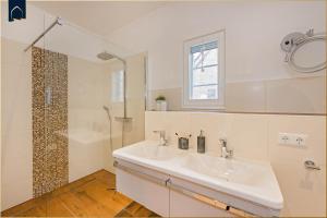 a white bathroom with a sink and a shower at Alte Post Liepe in Rankwitz