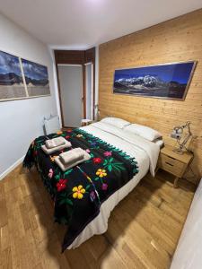 a bedroom with a large bed with a floral blanket at Apartamento de Montaña en Baqueira con Parking y Totalmente Equipado in Betrén